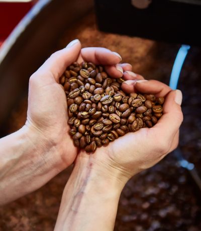close-up view of roasted coffee beans in womans hand
